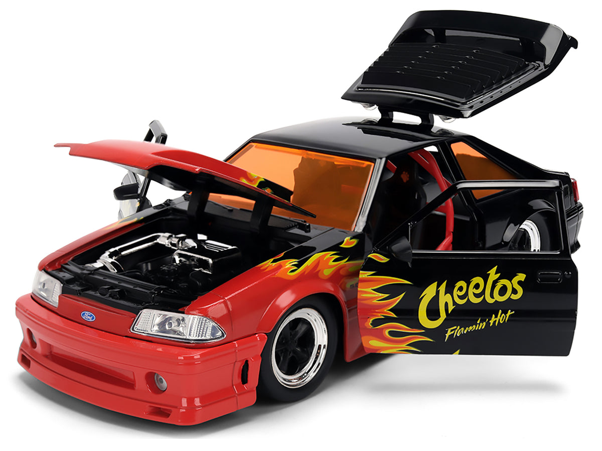 1989 Ford Mustang GT Black with Red Flame Graphics and Chester Cheetah Diecast Figure "Cheetos Flamin' Hot" "Hollywood Rides" Series 1/24 Diecast Model Car