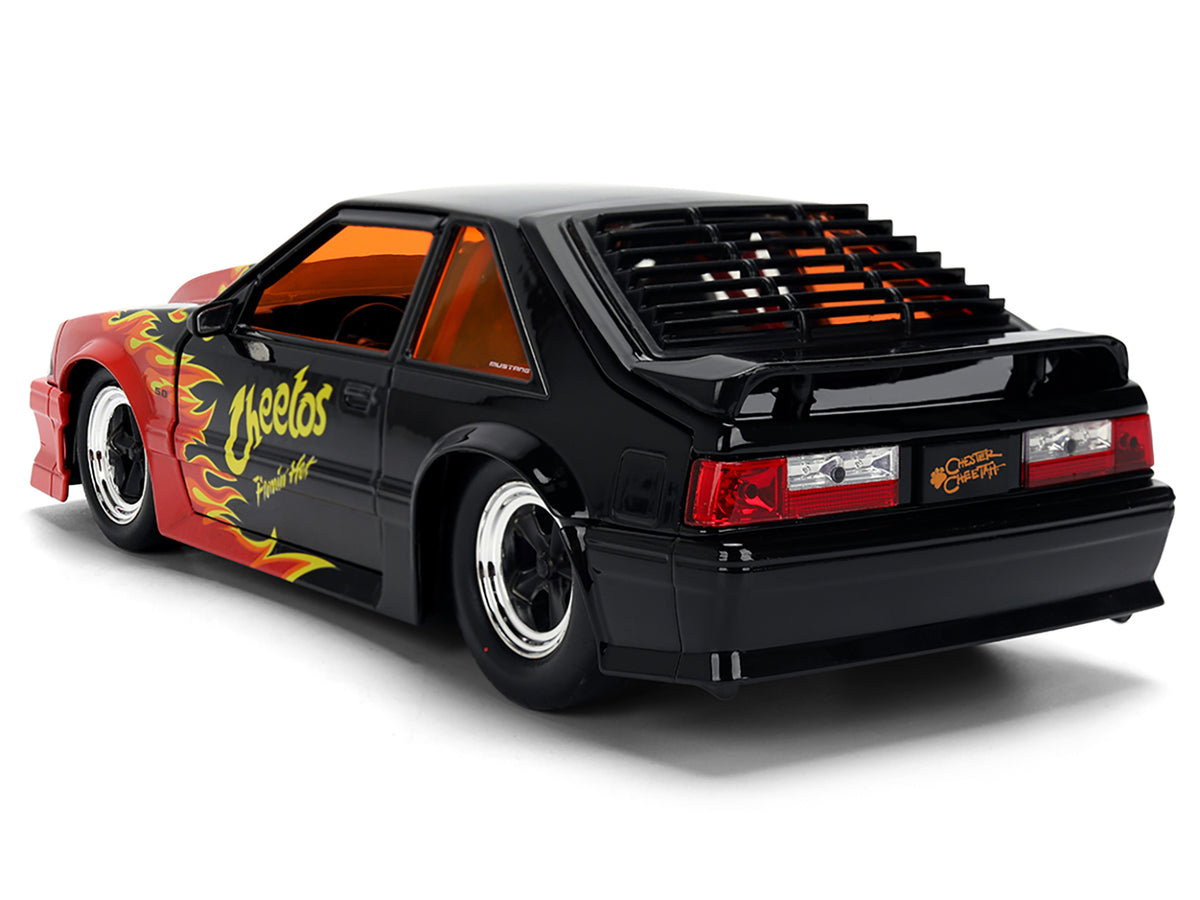 1989 Ford Mustang GT Black with Red Flame Graphics and Chester Cheetah Diecast Figure "Cheetos Flamin' Hot" "Hollywood Rides" Series 1/24 Diecast Model Car